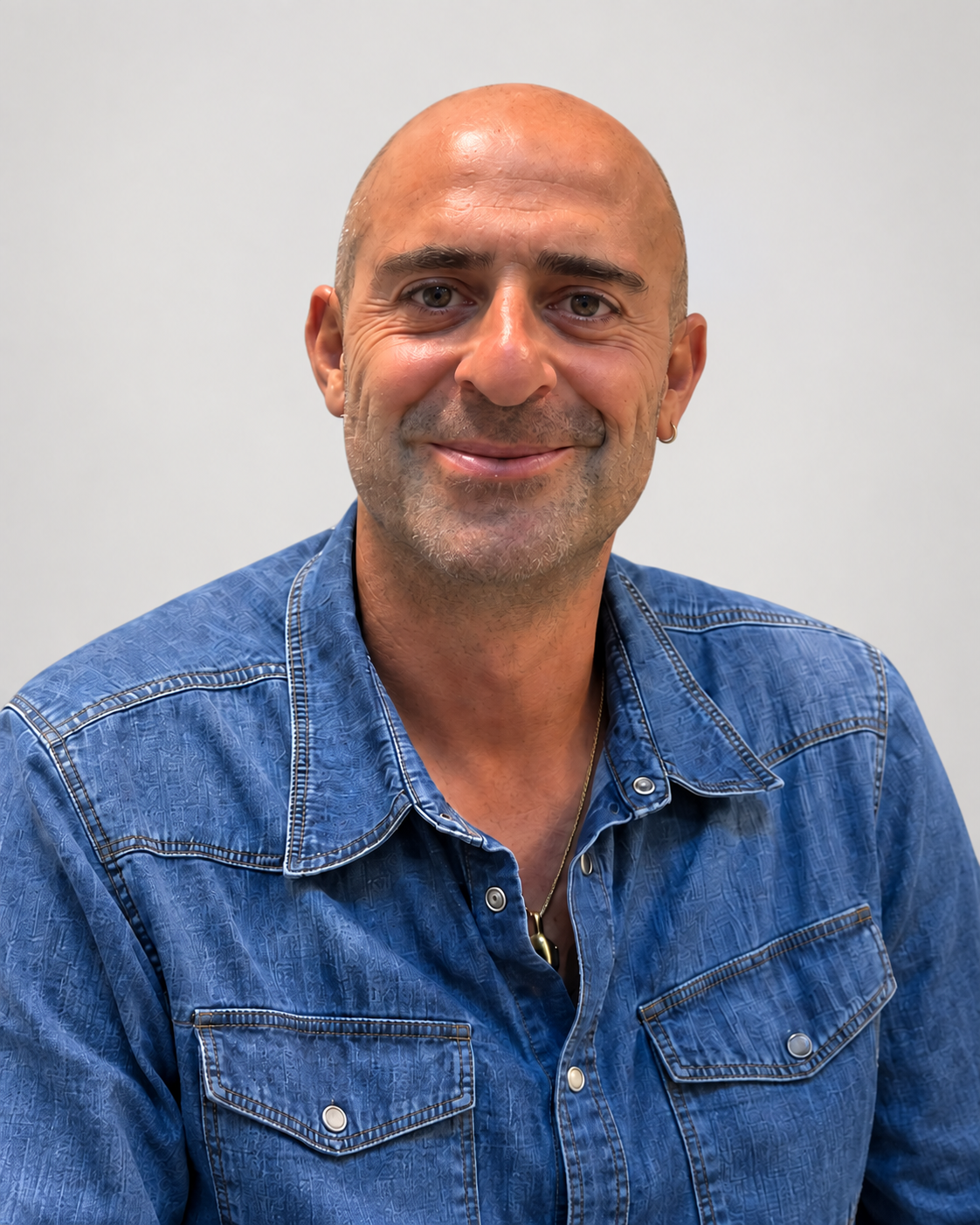 Leonardo Pompei, sorridente, in camicia blu, su sfondo chiaro